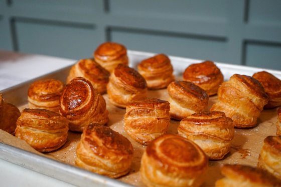 Baked flaky pastries on a metal baking sheet. 